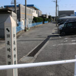 長崎街道の道標と街道。左に工場がみえる