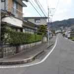 長崎街道と道標。奥に国道34号線と街道の交差点がみえる(大里町)