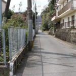 アパートの横をとおる長崎街道。フェンスに手作りの街道案内版(田中町)