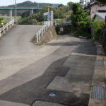 街道が国道34号線と合流。左のゆるやかな坂を登ると国道。右側の街道は民家の玄関へ向かうが、かつての街道はこのまま真っすぐ進んでいたと推測する(東彼杵町里郷1998)