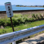 長崎街道の道標。後ろに線路(彼杵-千綿)と海(の上に日本二十六聖人の乗船場跡)が見える(東彼杵町彼杵宿郷837-10付近)