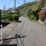 街道(小倉方面を振り返る)。奥に国道をわたる前の街道(坂道)が見える(千綿宿郷1052-4)