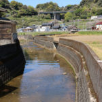 街道を横切る名もなき小さな川。奥に棚田と墓地が見える。(千綿宿郷1292)