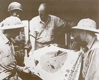 ガ島日本軍が持っていた日の丸を眺める連合軍人