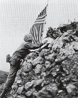 首里城陥落後、星条旗を掲げる米兵
